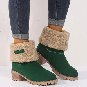 Close-up of green suede winter boots with beige fleece cuff and a chunky block heel.