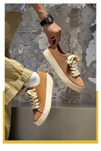 Dettaglio laterale di sneakers vintage in tela marrone da uomo con suole platform spesse.