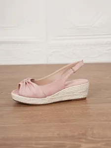 Side view of pink suede espadrille wedge sandal with jute rope sole and knot detail