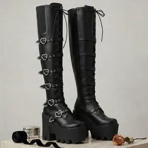 Détail de bottes cuissardes noires à plateforme punk avec boucles métalliques en forme de cœur