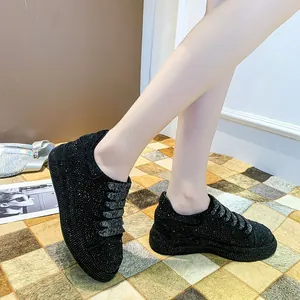 Close-up on-foot view of black platform sneakers fully covered in sparkling rhinestones