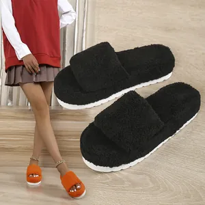 Detail of black fuzzy platform slides with soft teddy fabric and thick white sole.