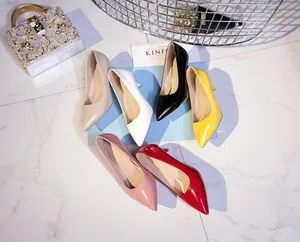 Close-up view of elegant colorful pointed-toe pumps on white marble background