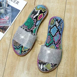 Detailweergave van glitterende strass-sandalen met kleurrijke slangenprint op het voetbed
