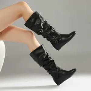 Detail view of black slouchy mid-calf boots with pleated design and buckle straps
