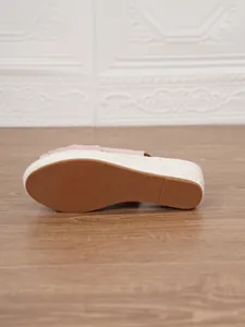 Close-up of the anti-slip brown rubber sole and straw wedge heel of the sandal