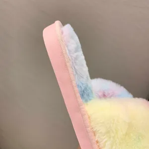 Close-up detail of rainbow plush texture and thick sole on indoor slippers.