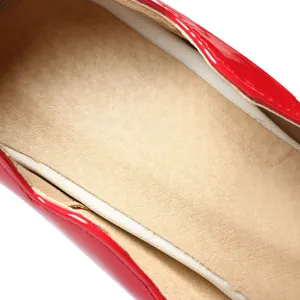 Vista macro detallada del forro interior beige y el zapato de tacón en charol rojo