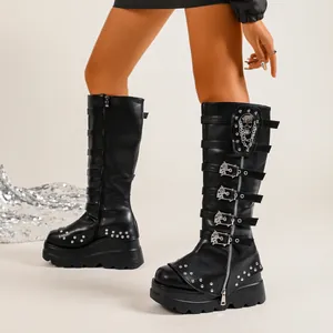Bottes hautes gothiques à plateforme avec boucles tête de mort et détails de chaîne.