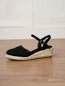 Vista lateral detallada de sandalia con cuña de ganchillo negro para mujer y suela de yute