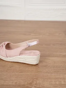 Detailed view of the pink suede wedge sandal with a jute rope platform heel