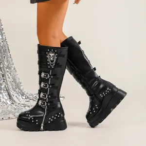 Détail de bottes montantes gothiques noires à boucles crâne et chaînes en métal
