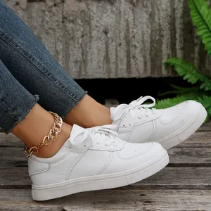 Seitenansicht weißer Plateau-Sneaker zum Schnüren, getragen mit einer goldener Fußkette