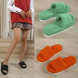 Detail view of plush fuzzy slides in green, orange and black with thick platform soles