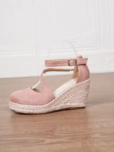 Vue latérale de sandales compensées en daim rose avec plateforme en corde tressée
