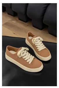 Vista laterale classica di sneakers in tela marrone vintage da uomo con lacci bianchi