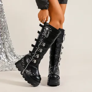 Détail de bottes montantes à plateforme gothiques noires avec boucles crâne et clous argentés