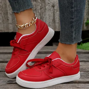 Nahaufnahme roter Schnür-Sneaker für Damen mit weißer flacher Sohle in Straßenszene