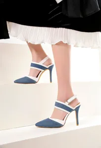 Detalle de las sandalias de punta en denim azul con elegantes correas blancas