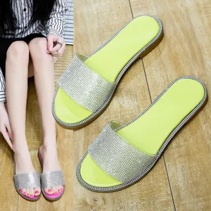Gedetailleerde close-up van fonkelende platte slippers met strassteentjes voor dames