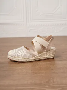 Vista detallada de sandalias de cuña tipo alpargata beige para mujer con bordado floral