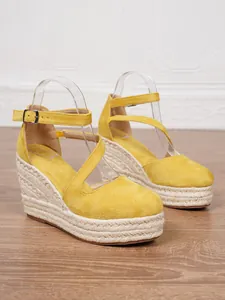 Detailansicht gelber Keilsandaletten aus Wildleder mit Espadrille-Plateau und Fesselriemen.