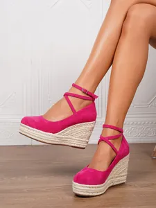 Sandalias de esparto con cuña en color rosa fucsia, puntera cerrada y tiras al tobillo