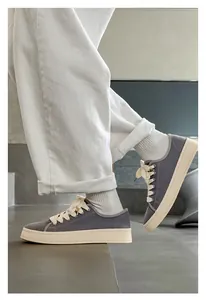 Dettaglio ravvicinato di sneakers retrò in tela grigia con suola platform