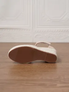 Vista inferior detallada de sandalia de cuña beige para mujer con suela de goma