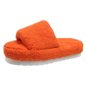 Detail view of orange plush fuzzy slides with thick white platform sole for winter