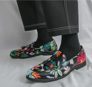 Detailed shot of men's black loafers with vibrant floral embroidery and stylish tassels