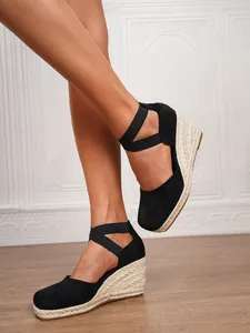 Detalle lateral de sandalias esparteñas de cuña en ante negro con suela de yute