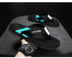 Primo piano di infradito da uomo nere e color teal con cinturini intrecciati e suola