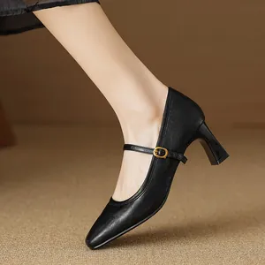 Detailed view of vintage black square-toe Mary Jane block heel pumps with buckle strap.