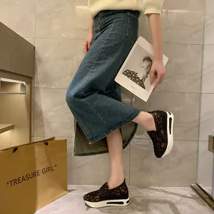 Detail shot showing black lace mesh platform loafers worn by model in casual setting