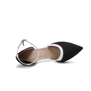 Close-up of black denim pointed-toe pumps with white ankle straps and stiletto heels
