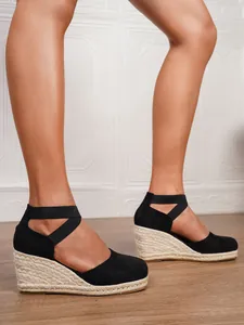 Vista detallada de sandalias de cuña de esparto negras para mujer con tiras elásticas