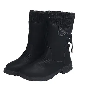Side view of black mid-calf boots featuring a cozy knitted cuff and studded flap detail