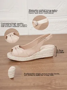 Detailed view of beige wedge sandals featuring straw-woven soles and velcro straps.