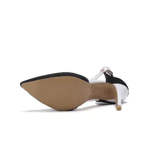 Detailed view of the tan sole and stiletto heel on a pointed toe denim slingback