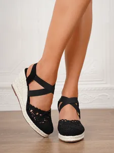 Detalle de sandalias de cuña de ganchillo negro para mujer con plataforma esparto