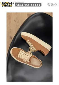 Vista dall'alto dettagliata di eleganti sneakers in tela marrone con spessi lacci color crema.