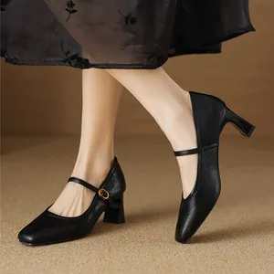 Close-up of vintage black square toe Mary Jane shoes with block heels and straps.
