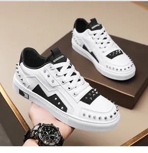 Close-up of white fashion sneakers featuring black lightning accents and silver studs.
