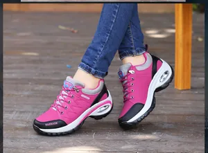 Primer plano de zapatillas rosas con cámara de aire sobre un fondo de madera natural.