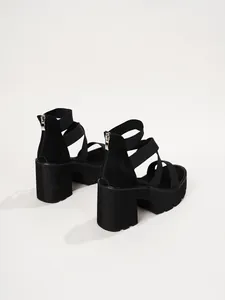 Vue arrière de sandales compensées noires avec des brides élastiques et fermeture