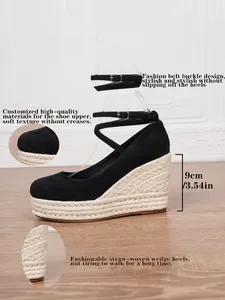 Vista detallada de elegantes sandalias de cuña en gamuza negra con tacón de paja