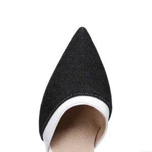 Detailed close-up showing the texture of the black denim pointed toe with white trim.