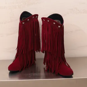 Nahaufnahme der weinroten Wildleder-Wadenstiefel mit langen Fransen und Sternennieten