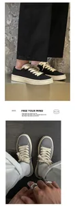 Vista dettagliata di sneaker vintage in tela nera e grigia con spessi lacci in cotone